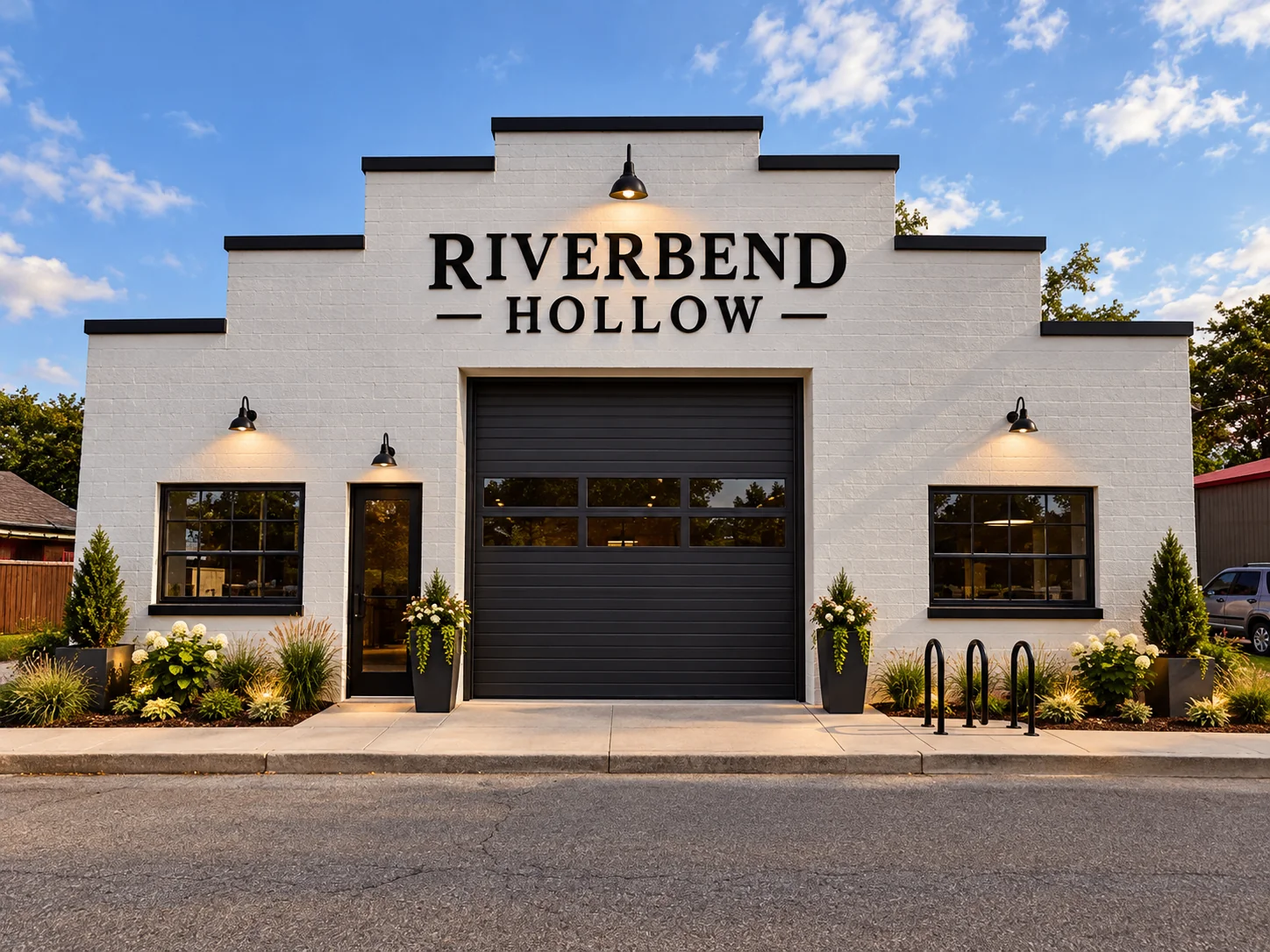Concept rendering of the renovated front of Riverbend Hollow: white painted facade, black garage door, lantern lights, planters and the Riverbend Hollow sign